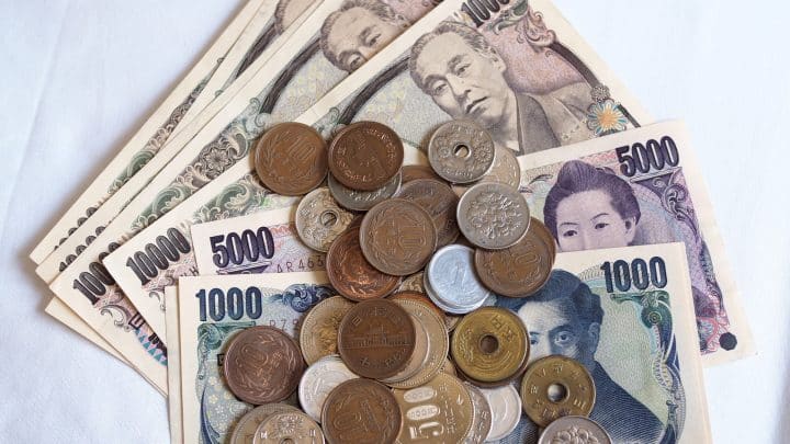 Japanese yen notes and coins on a plain background