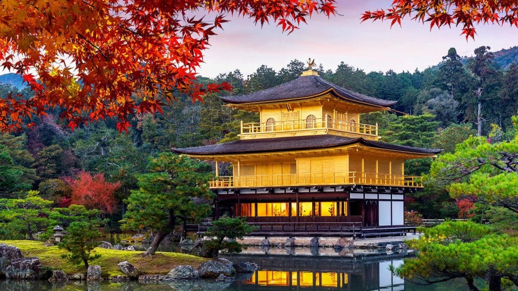 The Golden Pavilion in Kyoto surrounded by red maples in autumn