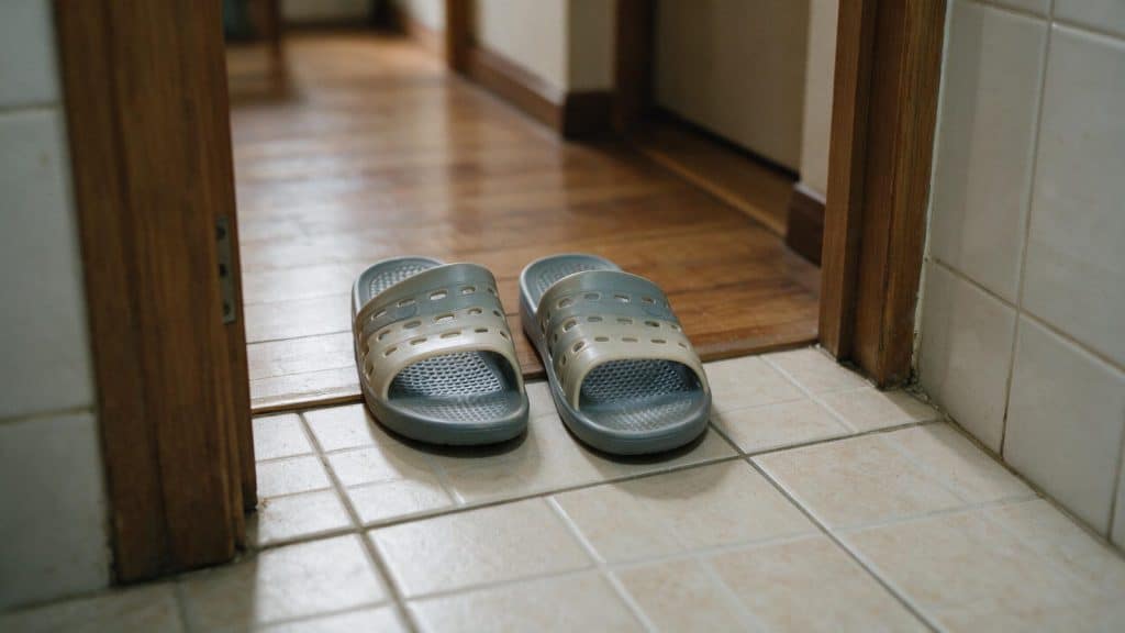 Plastic toilet slippers waiting just inside a bathroom doorway
