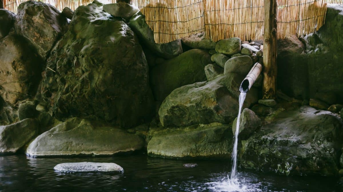 Steaming water running through a rocky outdoor onsen in Aomori, Japan