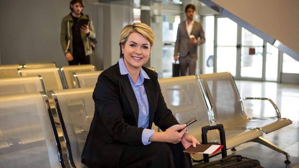 A traveller waiting with luggage in an airport departure area