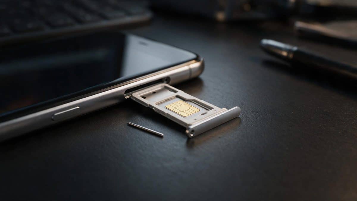 A smartphone with its SIM tray ejected and the SIM chip visible