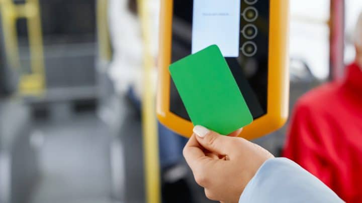 Passenger tapping a transport card on the card reader while boarding a bus