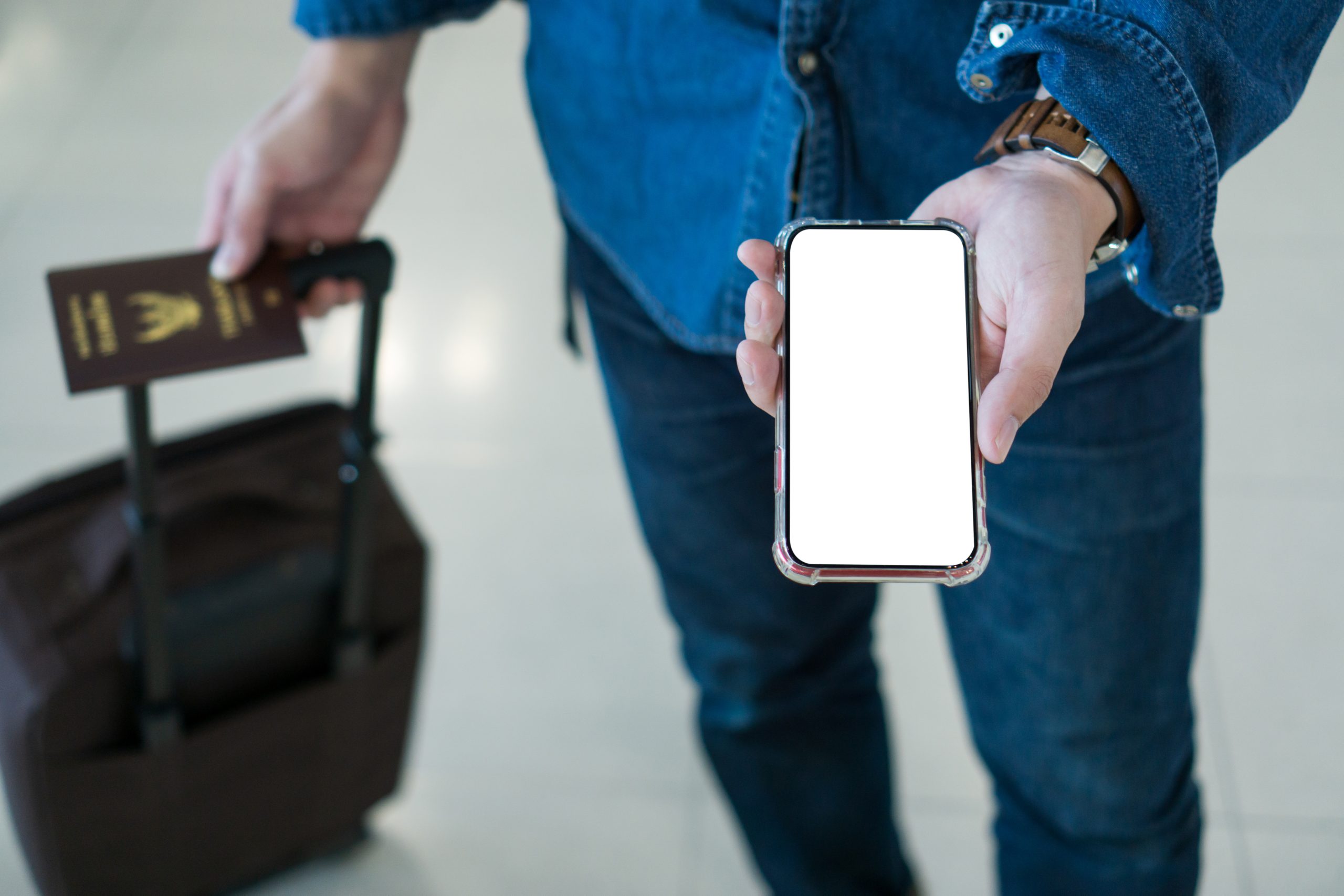 Traveler holding a passport and a phone showing a flight booking