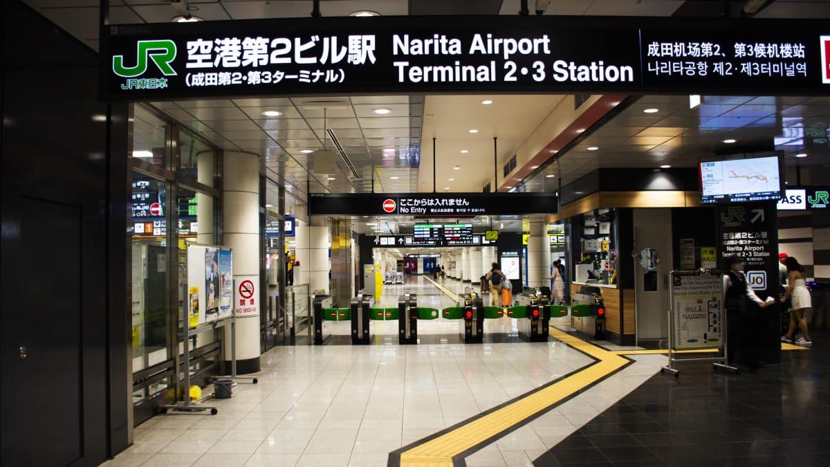 Travelers checking an information board at Narita International Airport