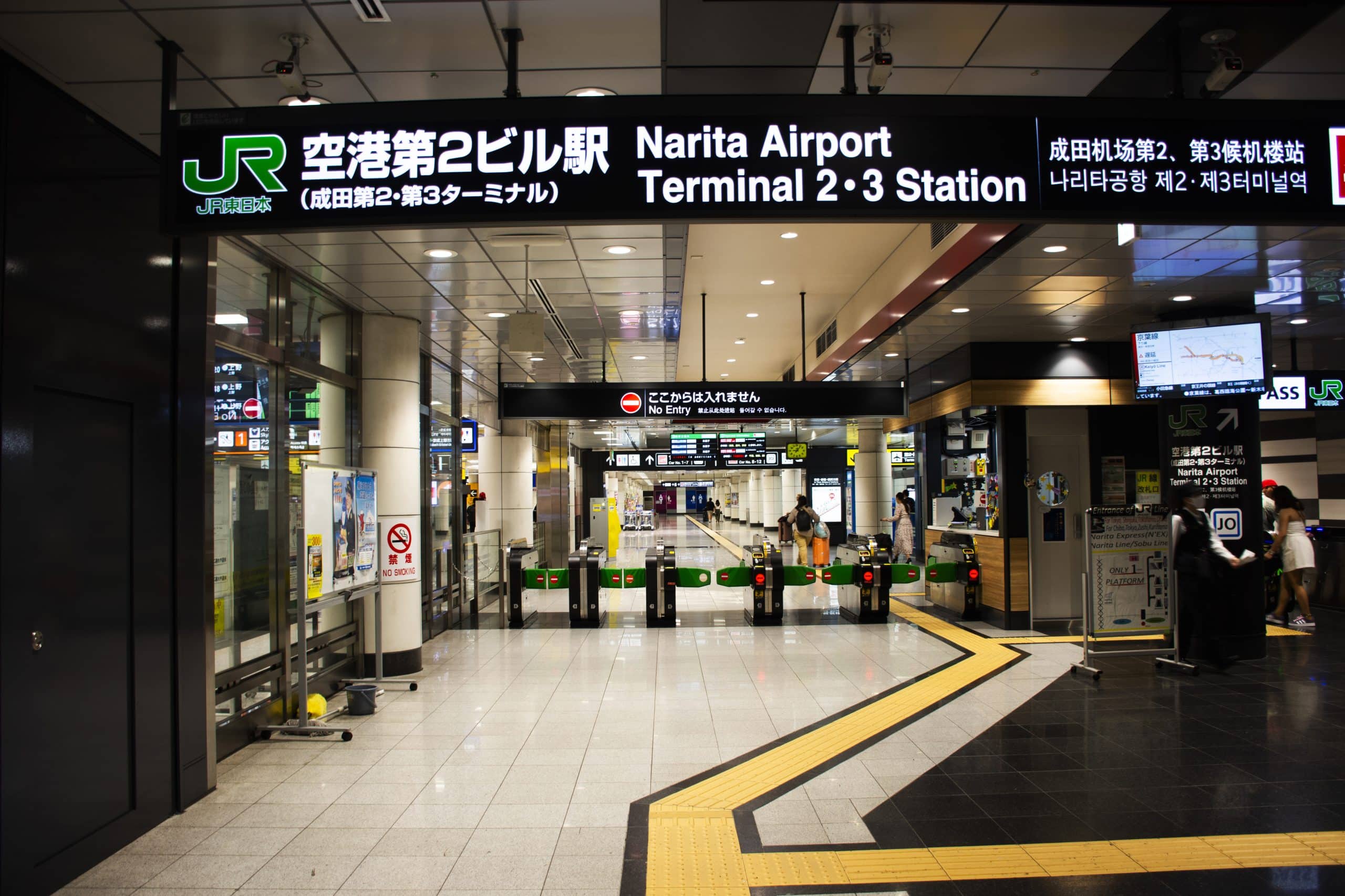 Travelers checking an information board at Narita International Airport