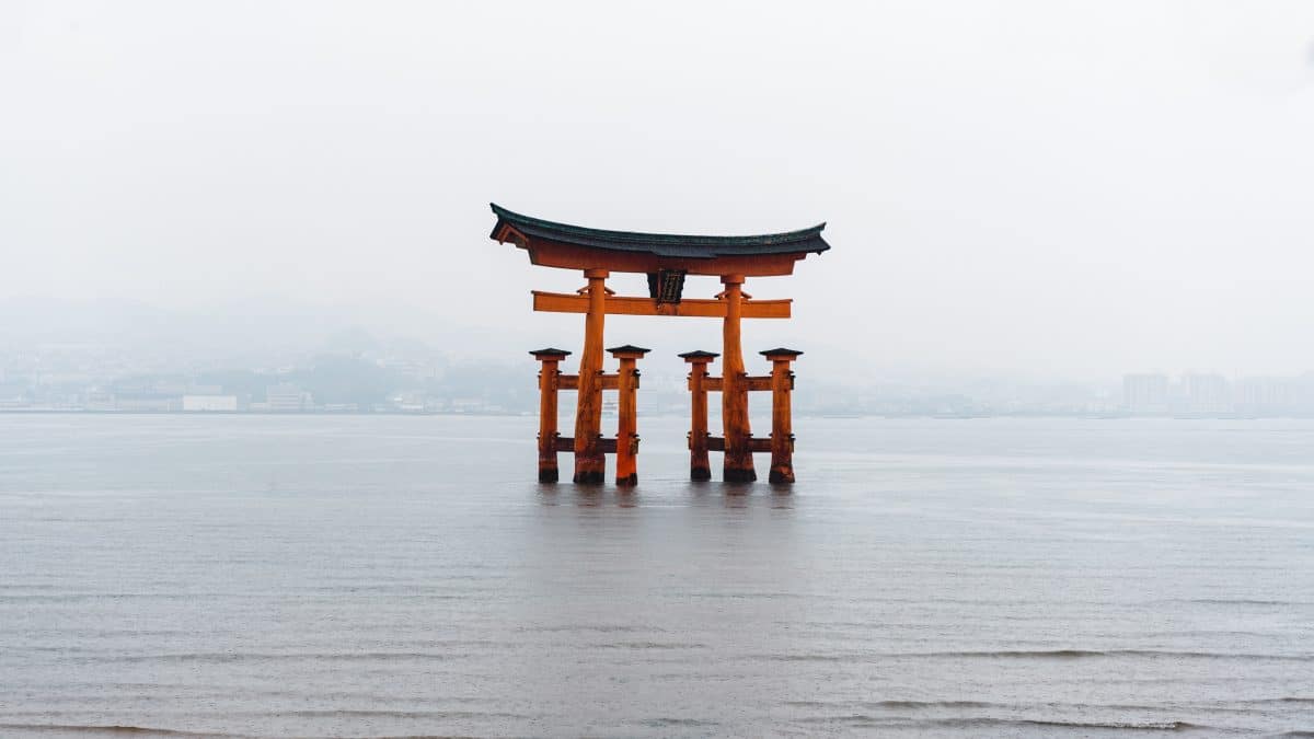 A traditional red torii gate marking the entrance to a Shinto shrine in Japan