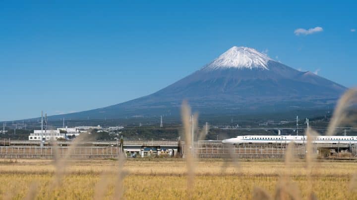 A Tokaido Shinkansen train crossing rice fields with Mount Fuji behind, in Fuji, Shizuoka
