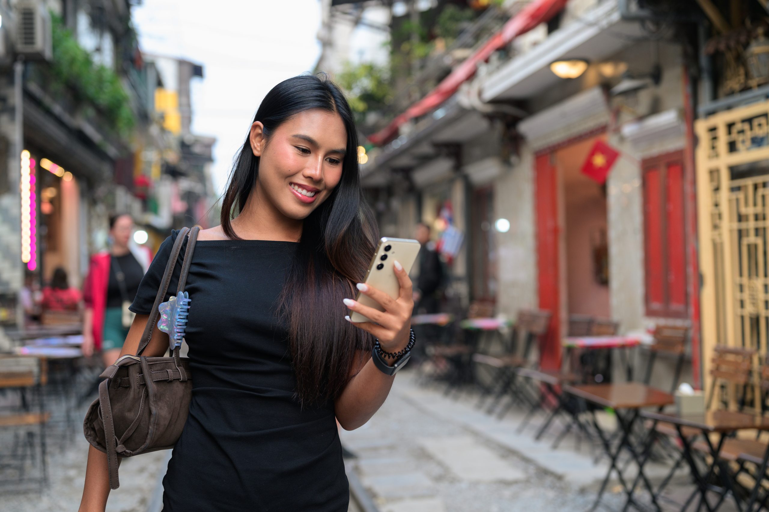 Traveler using a smartphone on Hanoi Train Street, Vietnam