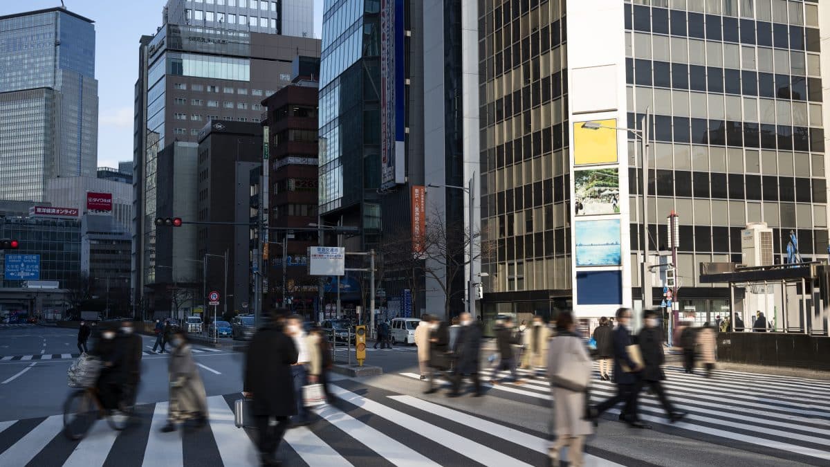 Pedestrians crossing a busy Tokyo street at a marked crosswalk