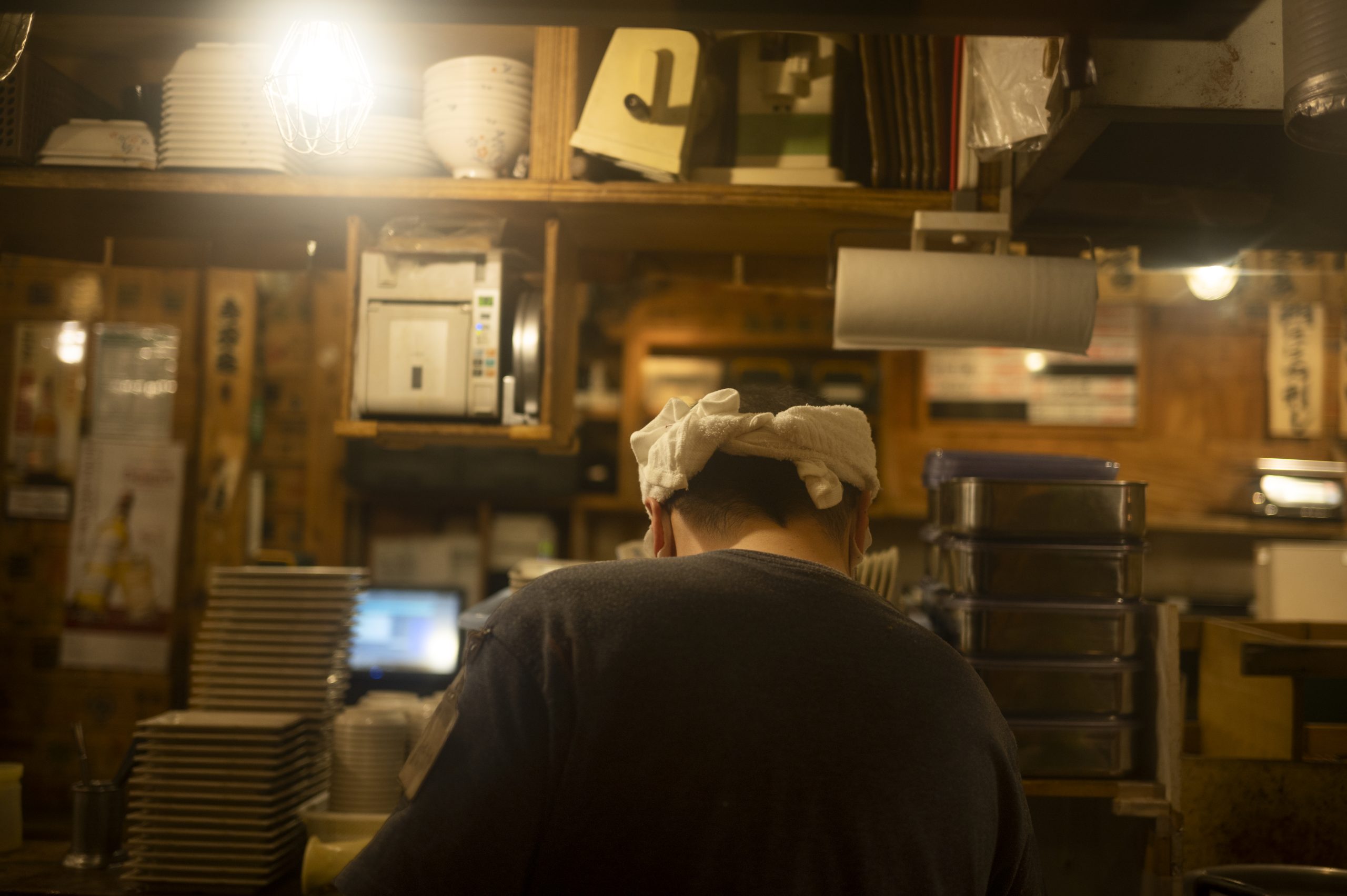 Small restaurants and izakaya signs along a narrow Tokyo street