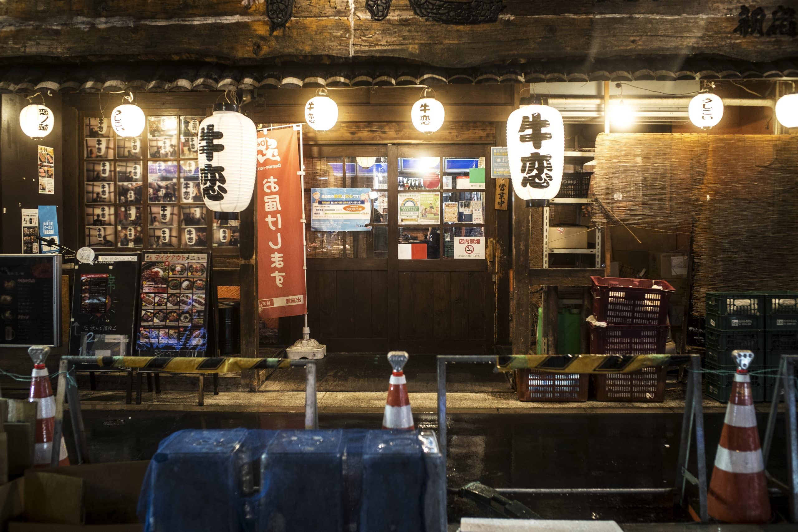 A row of small Japanese food and drink stalls lit up at night, the type of older izakaya venue that can be exempt from the indoor smoking ban
