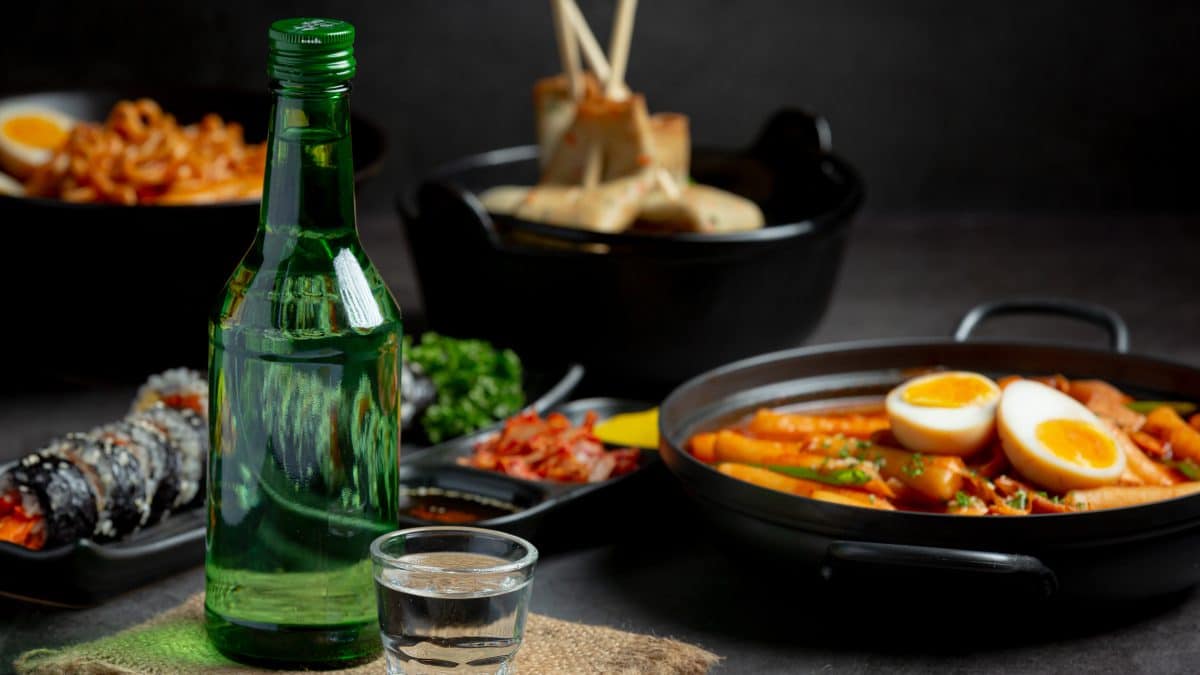 Green soju bottles and banchan side dishes on a Korean restaurant table