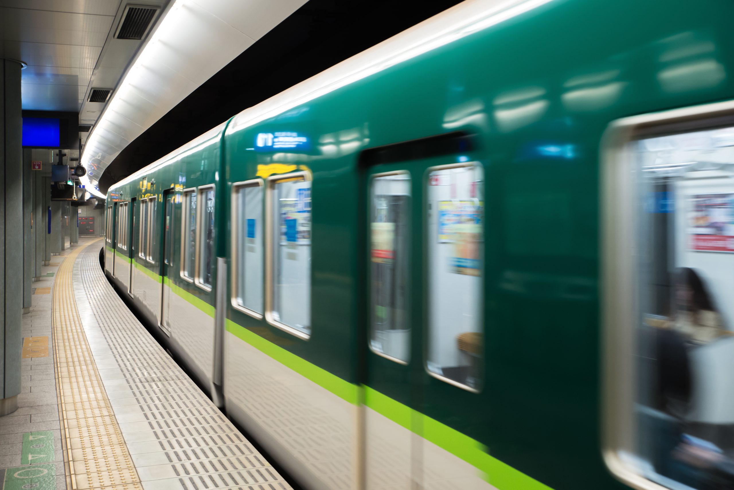Commuters on a Tokyo subway platform as a train pulls in