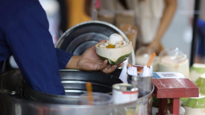 Ice cream vendor serving tourists at a street market in Thailand