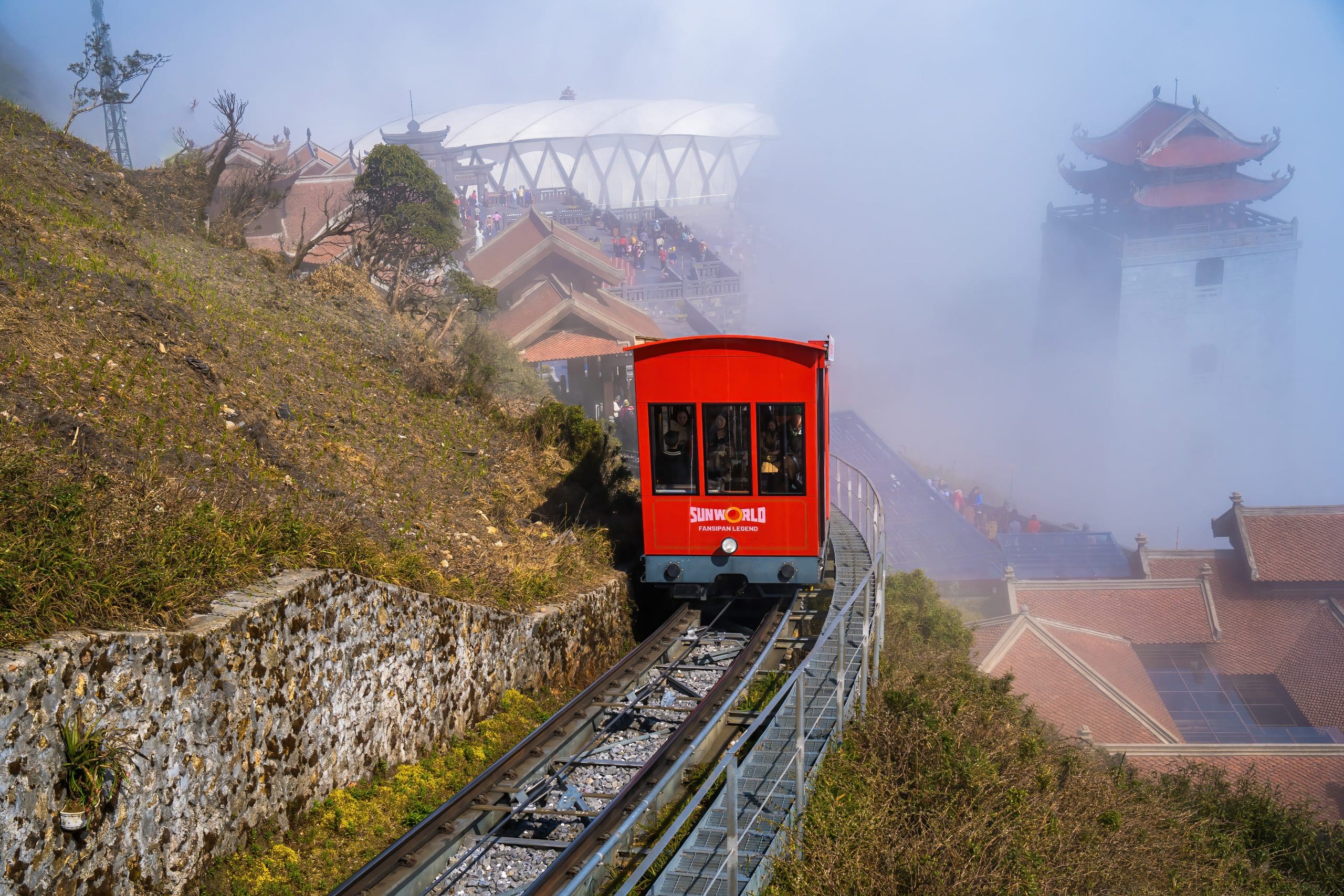 Mountain railway leaving Sapa station toward Fansipan in morning fog