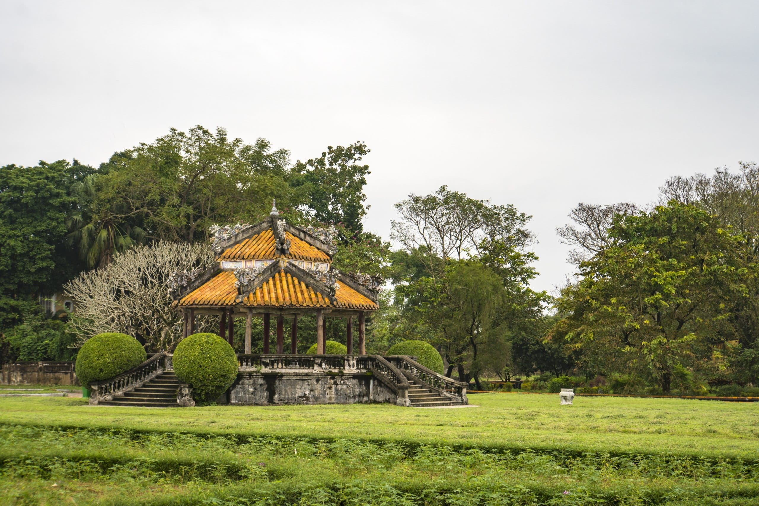 Traditional Vietnamese pavilions in the garden of the Imperial City of Hue under a blue sky