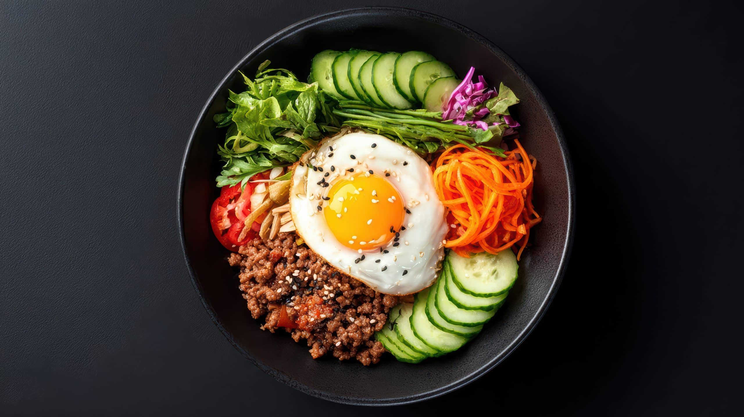 Bowl of bibimbap with rice, fried egg and assorted vegetables